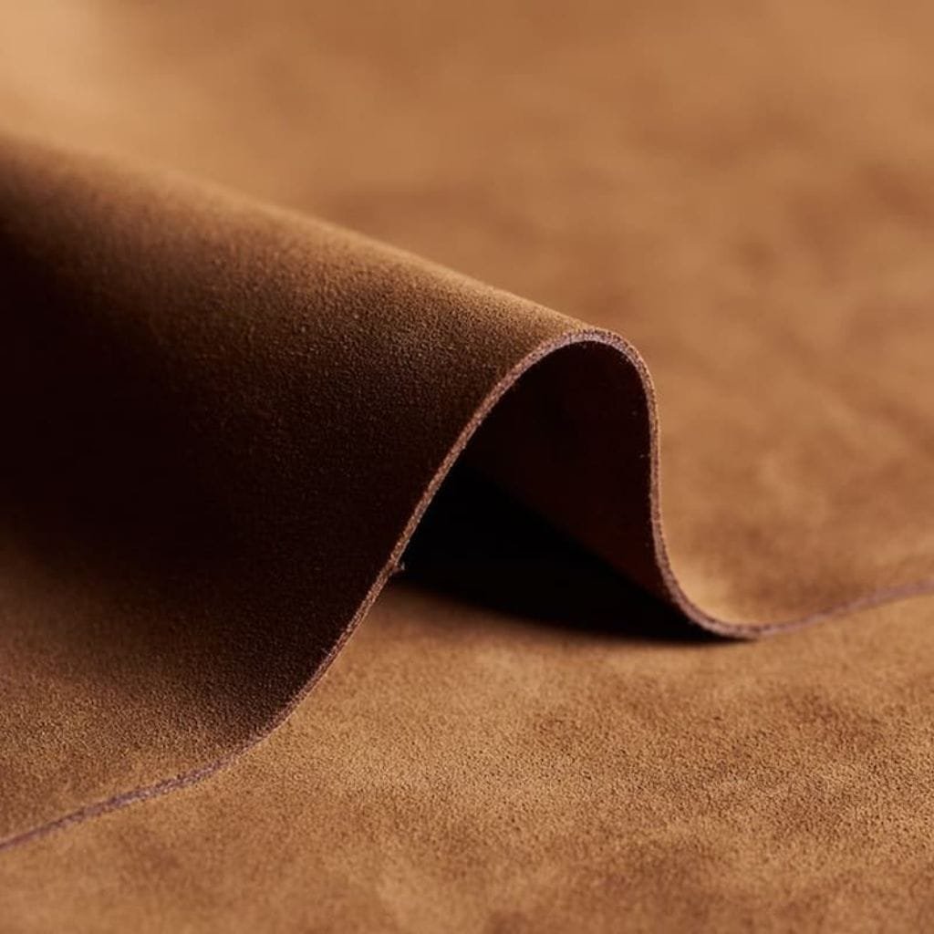 Nubuck Leather: Luxurious, Durable, and Soft to the Touch. Close-up of brown nubuck leather, showcasing its soft, velvety texture and fine surface grain.