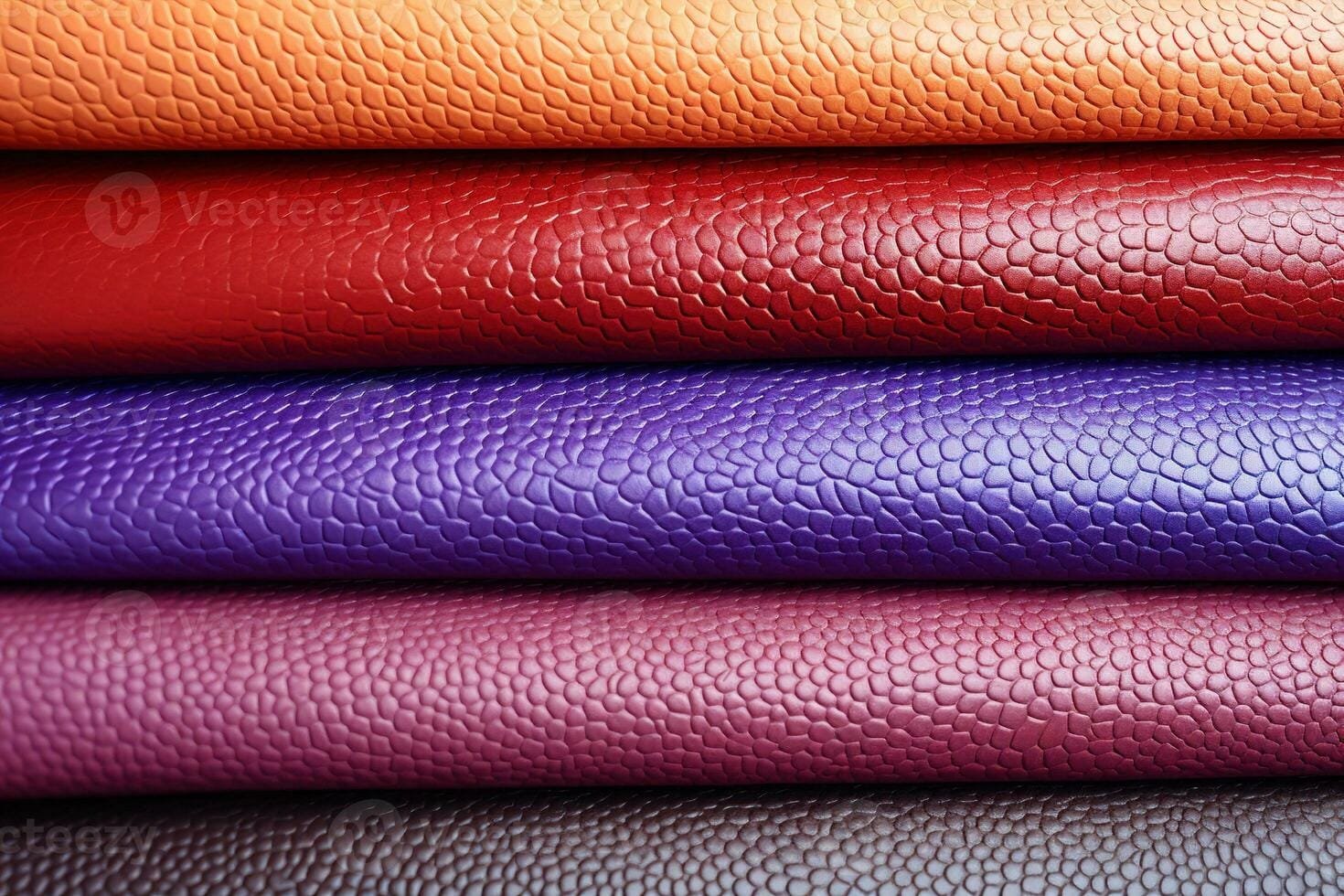 A stack of five folded pieces of faux leather or leather-like fabric in various colors, arranged from top to bottom: mustard yellow, red, beige, black, and dark brown.