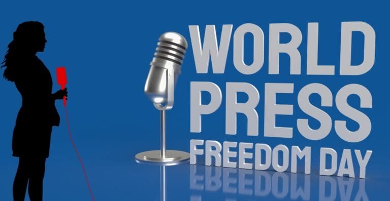 A silhouette of a woman holding a red microphone on the left, speaking into a large silver microphone icon. To the right, the text reads "WORLD PRESS FREEDOM DAY" in large letters.