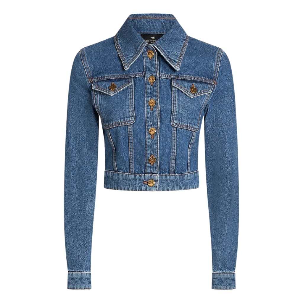 A classic blue denim cropped jacket with long sleeves, a pointed collar, and metal button closures down the front. The jacket features two chest pockets with button flaps and visible stitching details.
