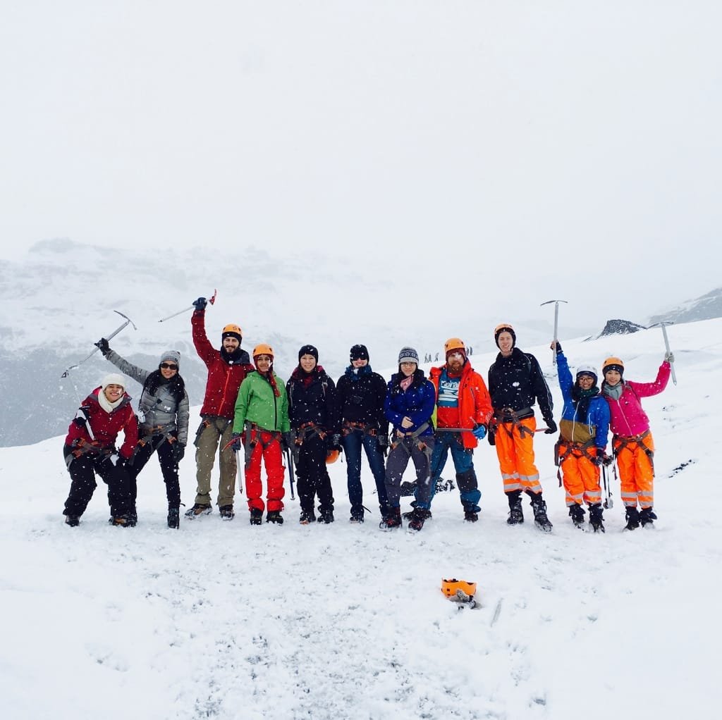 A group of people enjoying a snowy outdoor adventure, wearing various colorful cold weather jackets suitable for men, women, and kids.