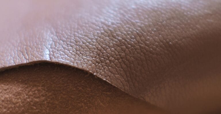 Close-up image of textured brown corrected grain leather showing fine surface details and natural grain patterns.
