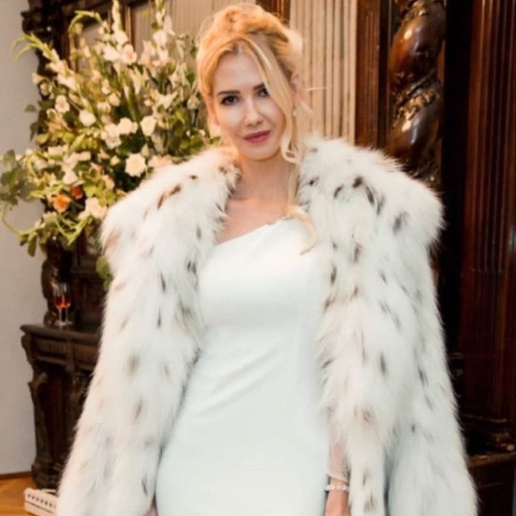 Elegant woman wearing a long faux fur coat over an evening dress, ready for a formal night out.