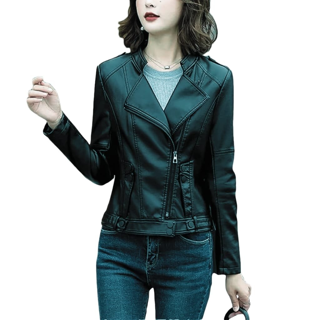 A woman wearing a black leather jacket and blue jeans, with medium-length wavy hair and jewelry, standing against a plain white background.