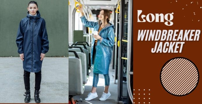 A woman wearing a long, navy blue windbreaker jacket standing outdoors on a pavement, with a plain green background behind her.