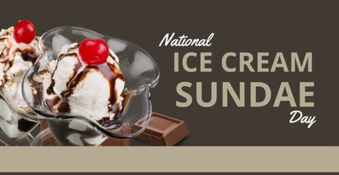Two scoops of vanilla ice cream topped with chocolate syrup and a cherry, served in a glass bowl with pieces of chocolate in the background, celebrating National Ice Cream Sundae Day.