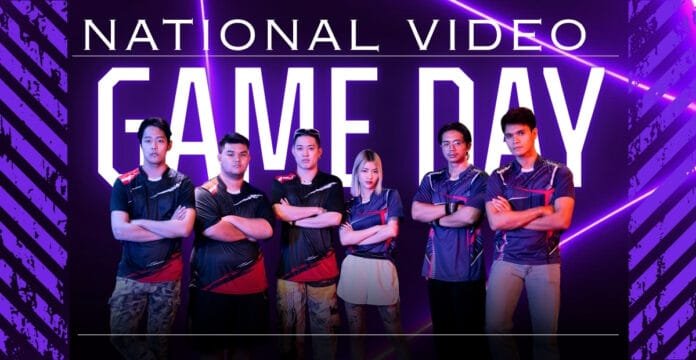 A group of six young people standing confidently with crossed arms in front of a neon-lit backdrop that reads 