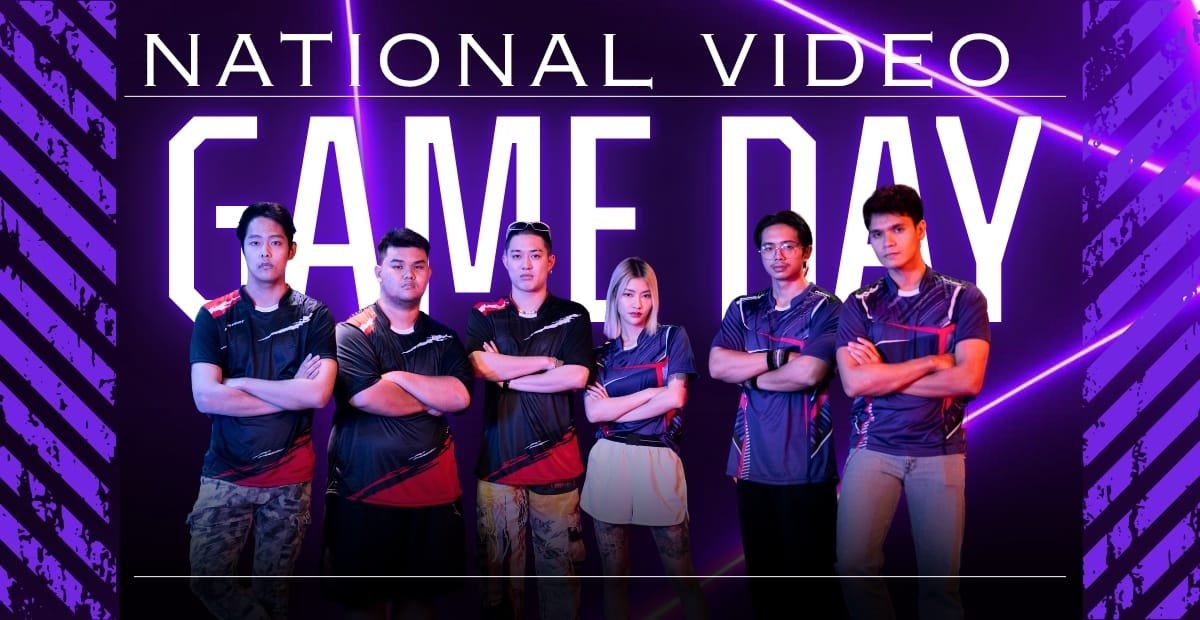 A group of six young people standing confidently with crossed arms in front of a neon-lit backdrop that reads "National Video Game Day." The background features purple and blue neon lines and abstract patterns, creating a vibrant, energetic atmosphere.