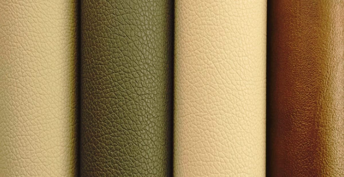 PVC Leather: A Durable & Affordable Faux Leather Close-up image of five textured leather rolls in shades of beige, green, cream, and brown arranged vertically.