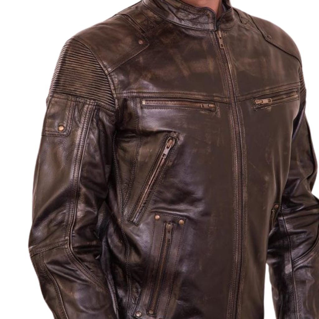 A close-up image of a dark brown cowhide leather shirt jacket featuring multiple zippered pockets, detailed stitching, and quilted shoulder accents.