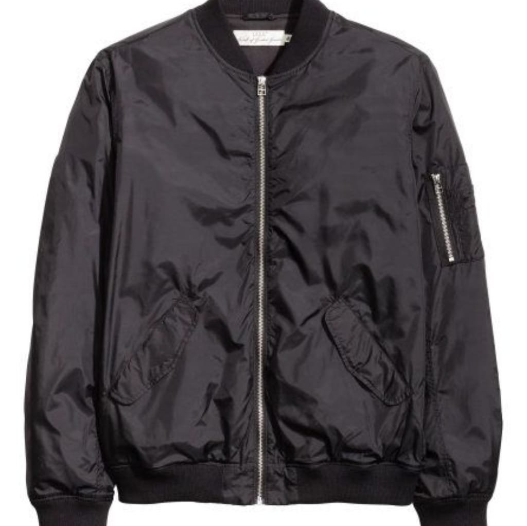 A black satin bomber jacket with a front zipper, ribbed cuffs and collar, and a zippered pocket on the left sleeve.