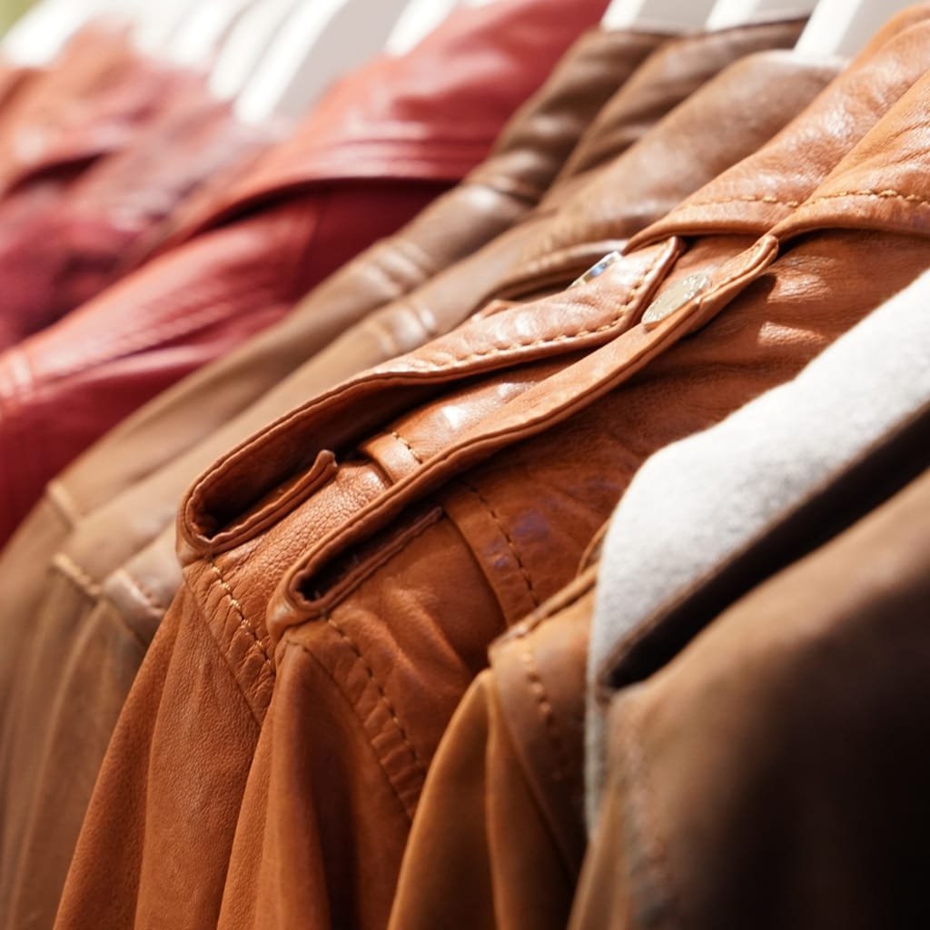 What Is a Leather Jacket? A Timeless Icon of Style and Attitude 40 A row of leather jackets hanging on a clothing rack, showcasing various shades of brown and tan.
