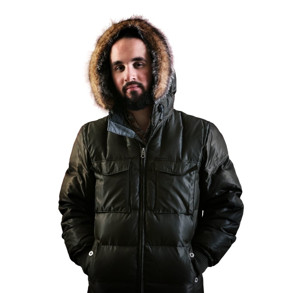 A man wearing a stylish black parka jacket with a fur-lined hood, standing against a white background.


