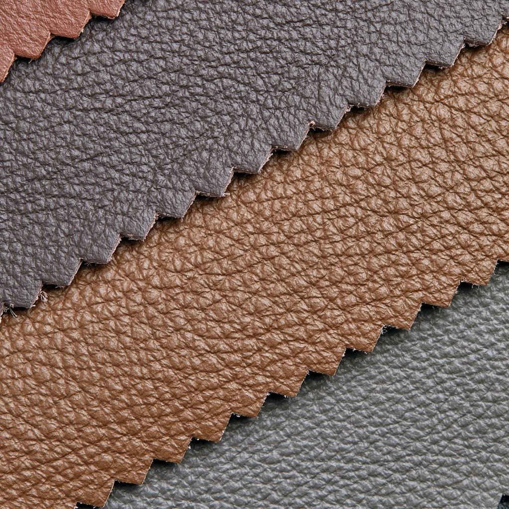 Close-up image of overlapping textured leather swatches, showcasing suede and nubuck finishes in shades of brown and gray with a soft, matte surface.

