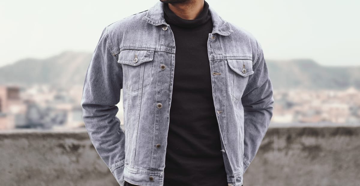 Trucker Jacket Style Guide: Rugged Looks for Every Season Blue trucker jacket styled over a black shirt for a sleek casual look