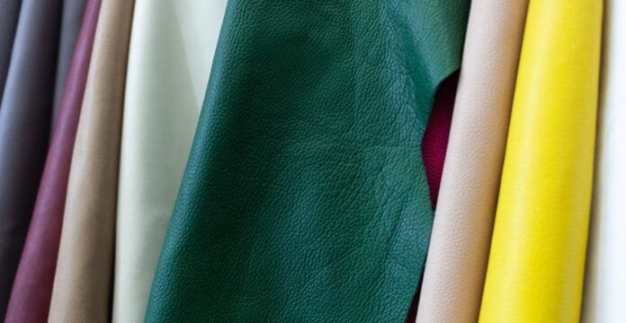 Close-up image showing a variety of cow’s leather samples in different colors and textures, including green, yellow, beige, and brown.