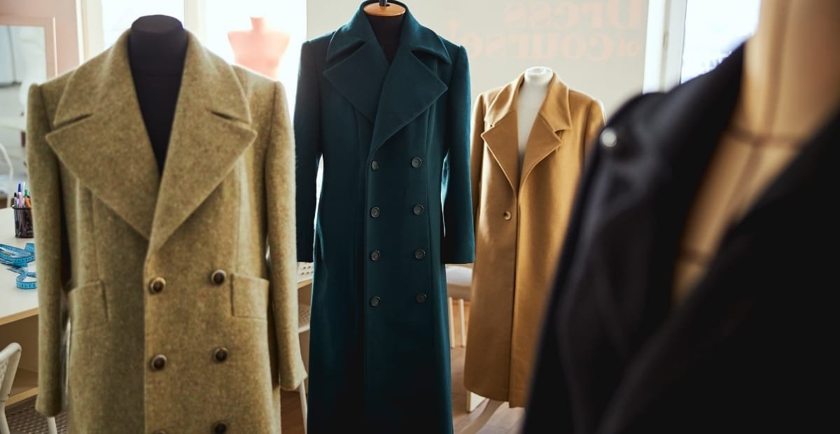 Wool Coat Styles That Blend Classic Warmth an Modern A display of four wool coats on mannequins, featuring various styles in different colors and cuts.