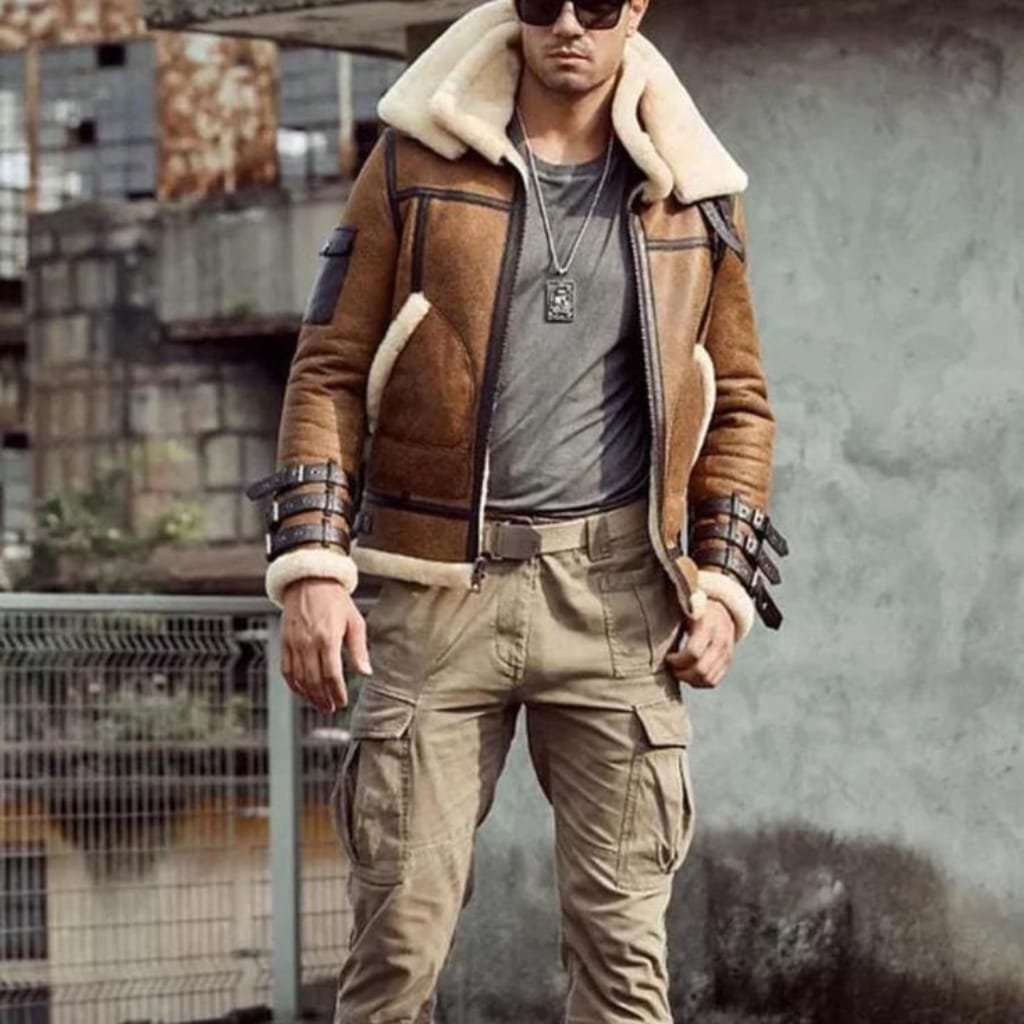 Man wearing a classic flight jacket with ribbed cuffs and a shearling collar, standing confidently outdoors.