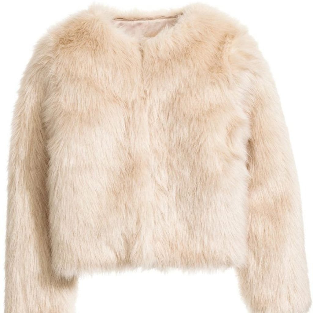 Luxurious ladies faux fur jacket in soft cream color with plush texture and elegant finish.