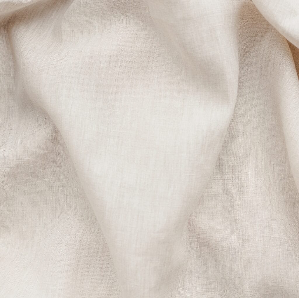 Close-up image of a light beige or cream-colored linen fabric with soft folds.