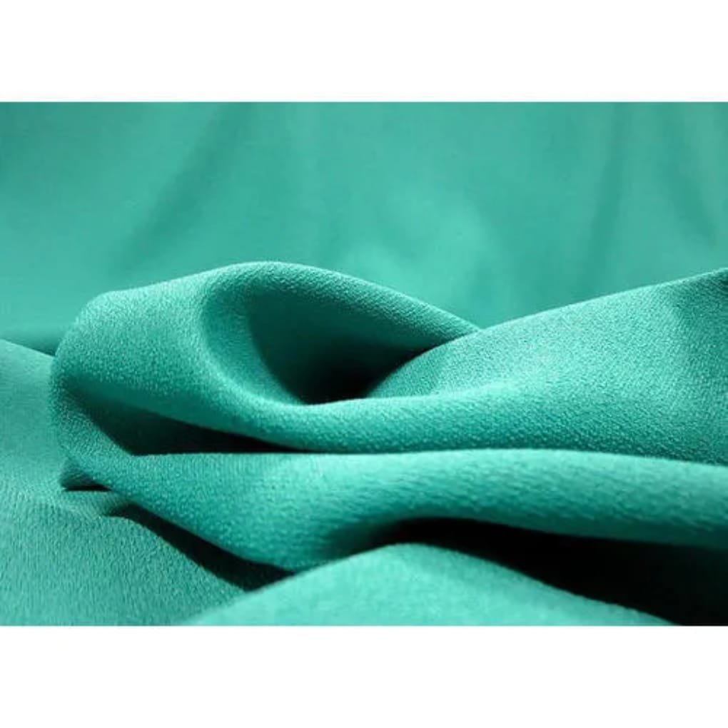 Close-up of teal green fabric with soft, smooth texture and flowing folds.