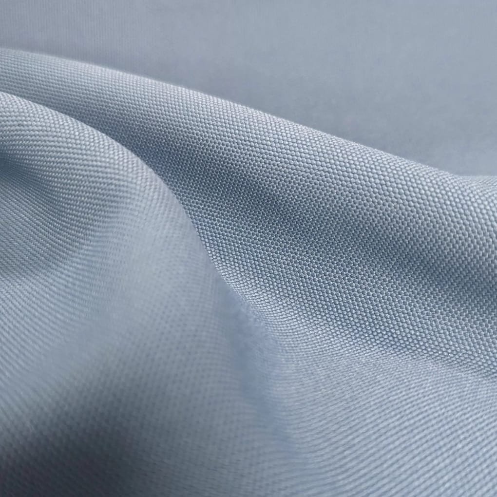 Close-up of light blue fabric with a tight, textured weave and soft folds.