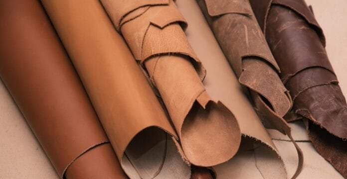 Close-up image of rolled and folded pieces of flexible buffalo leather in various shades of brown.