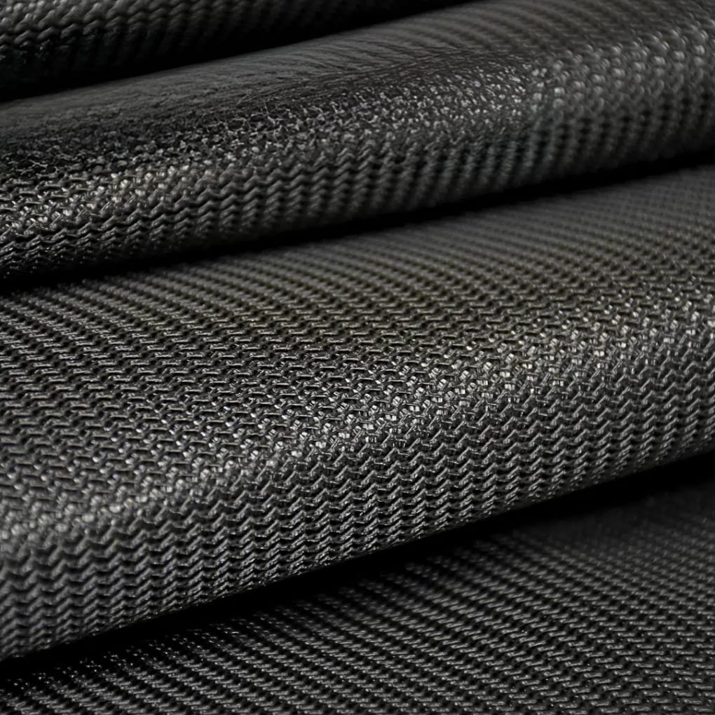 A close-up of stacked black textured fabric with a tight, diagonal weave pattern and subtle shine.