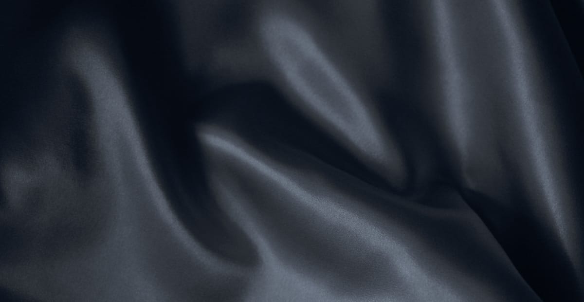 Holland Linen Fabric: Soft, Durable, and Perfectly Stylish A close-up view of dark blue linen fabric with soft, flowing folds and gentle sheen.