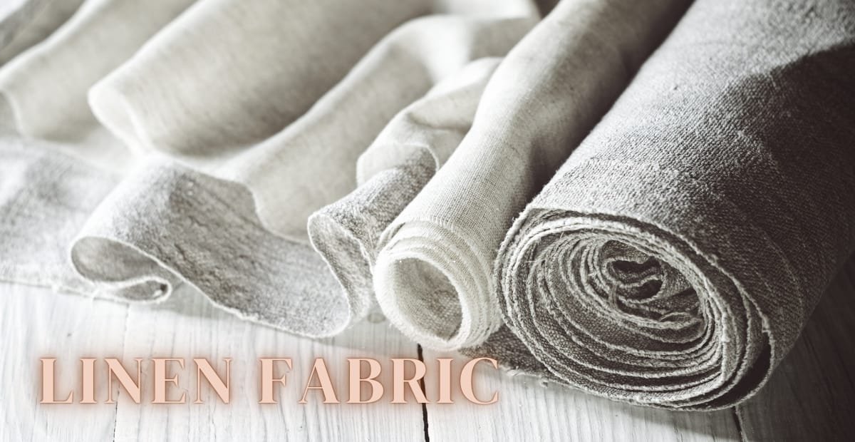 Linen Fabric: A Complete Guide to History, Uses, and Benefits Close-up image of rolled and folded linen fabric in light neutral tones, placed on a wooden surface with the words "LINEN FABRIC" overlaid.