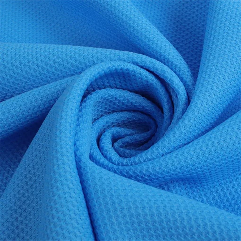 Close-up of bright blue fabric folded into a swirl, showing a textured, honeycomb-like weave.