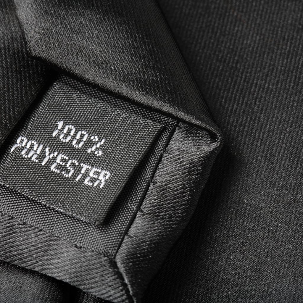  A close-up of a black garment tag reading “100% COTTON” (appears blurred) with textured fabric around.