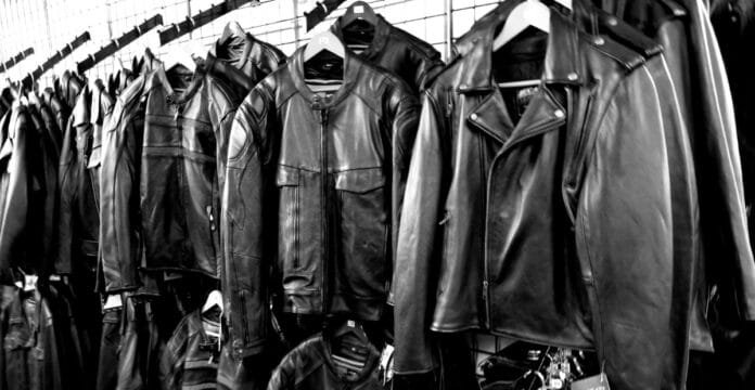 A display of black leather A-2 bomber jackets hanging on a clothing rack, arranged in rows.