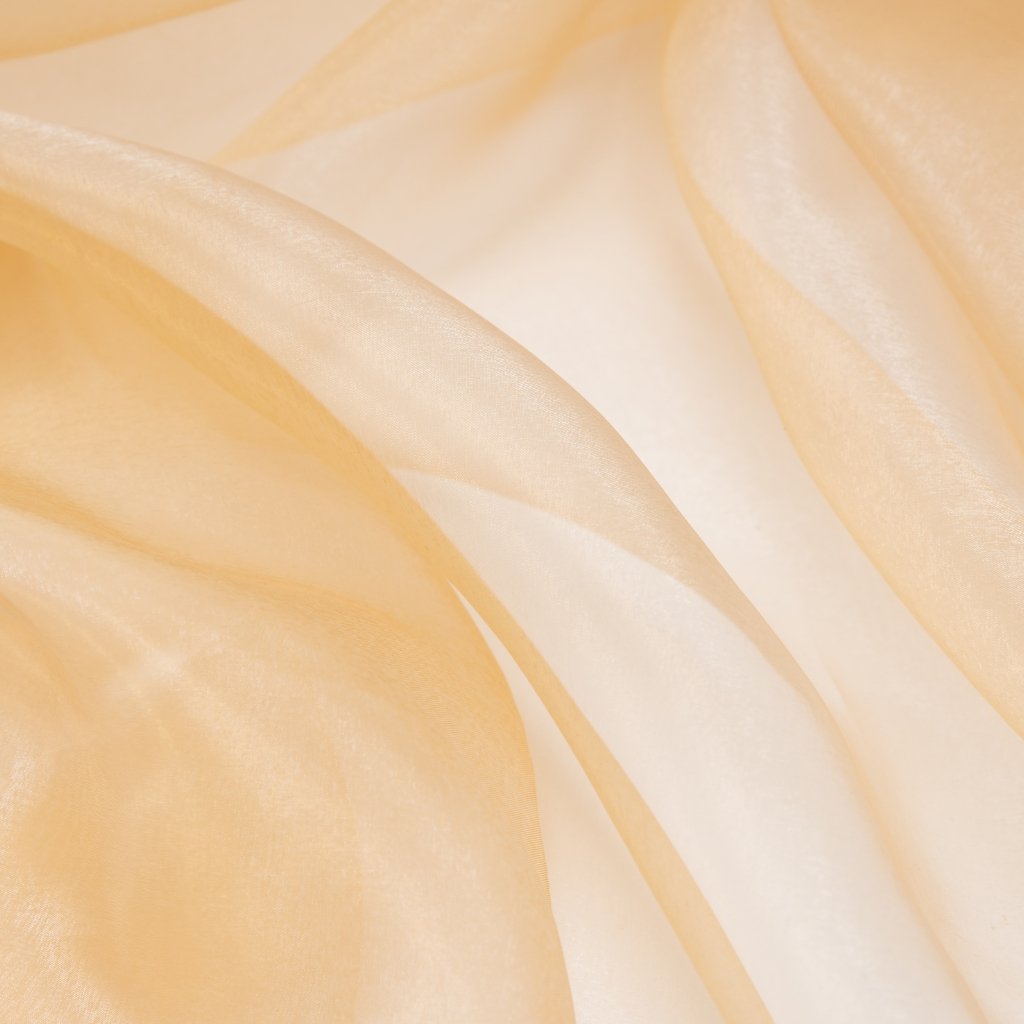 Soft, peach-toned crushed organza fabric with gentle folds and a sheer, shimmering texture.