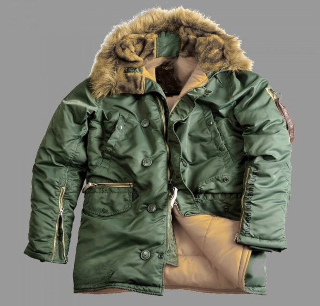 "Green B-15 bomber jacket with a fur-lined hood, multiple pockets, and tan inner lining; zippers and buttons visible against a gray background."
