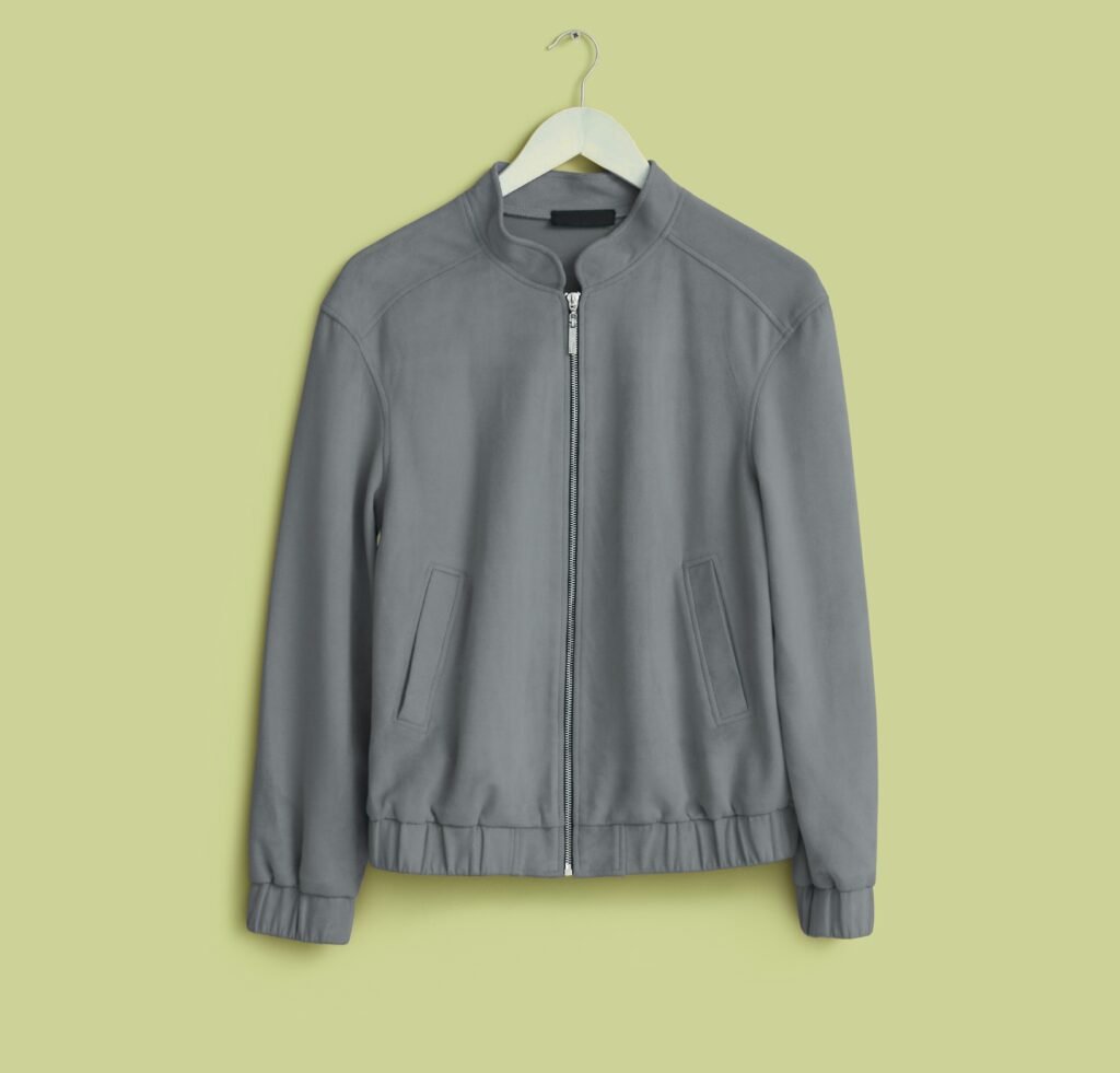 Gray slim-fit bomber jacket with front zip, stand collar, and angled pockets on a hanger against a pale yellow-green background.
