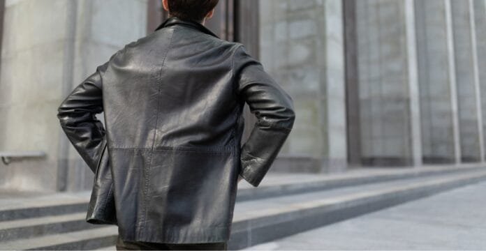 A person wearing a black leather jacket seen from behind.