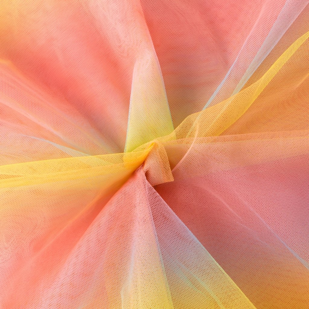 Close-up of peach, pink, and yellow crushed organza fabric gathered at the center, showing sheer, airy layers and soft color transitions.