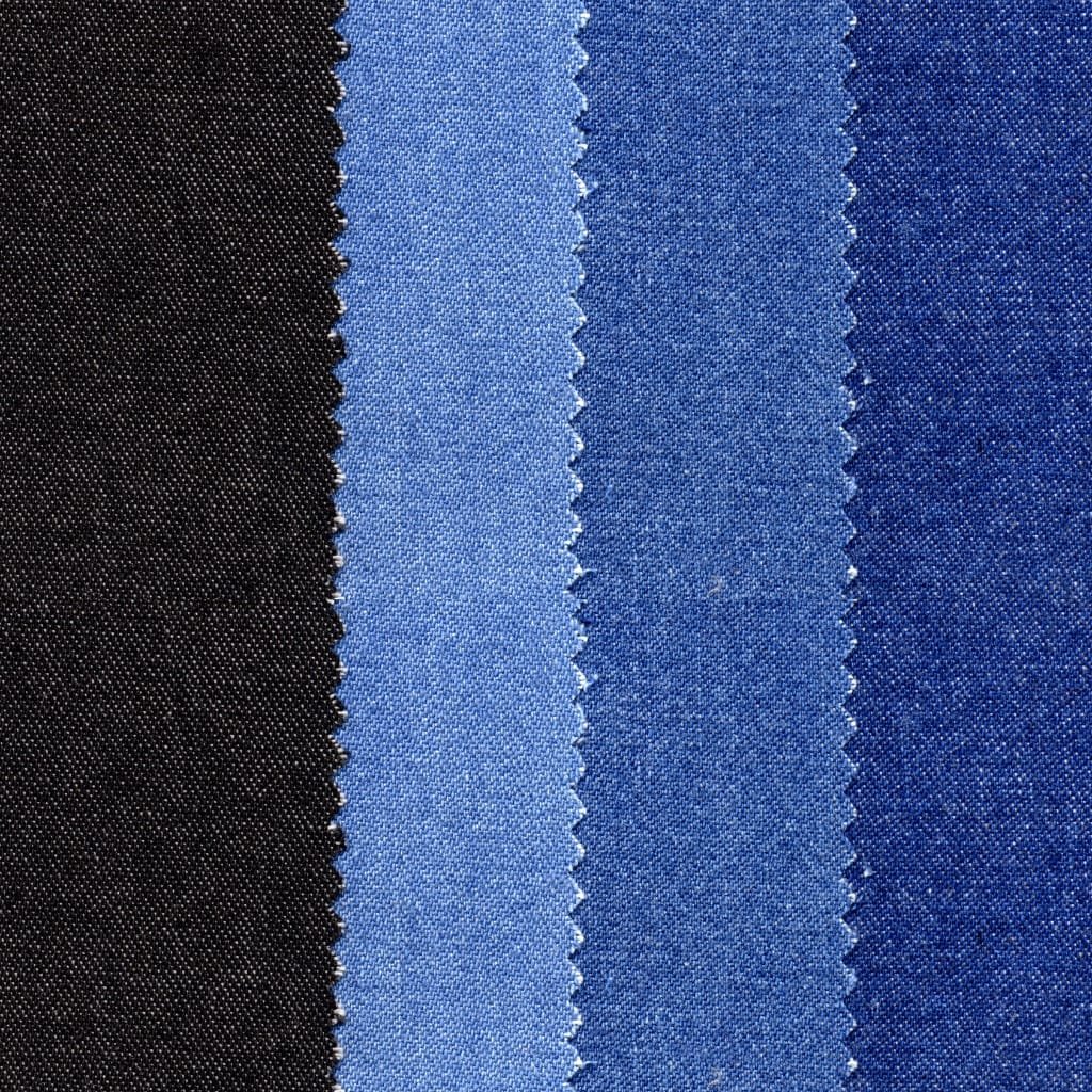 Close-up of classic blue denim fabric with visible diagonal weave and varying indigo shades.

