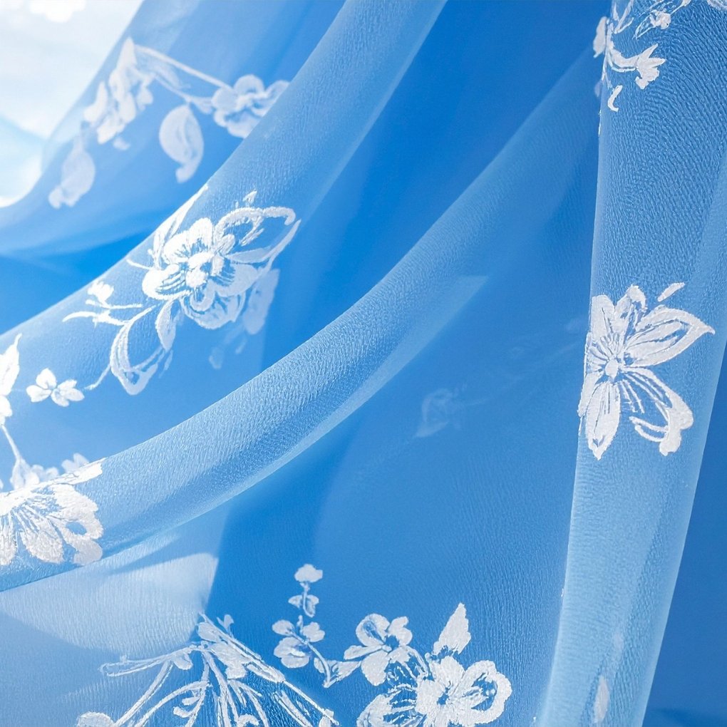 Transparent blue organza with white embroidered floral patterns, showing delicate sheer fabric and crisp embroidery.