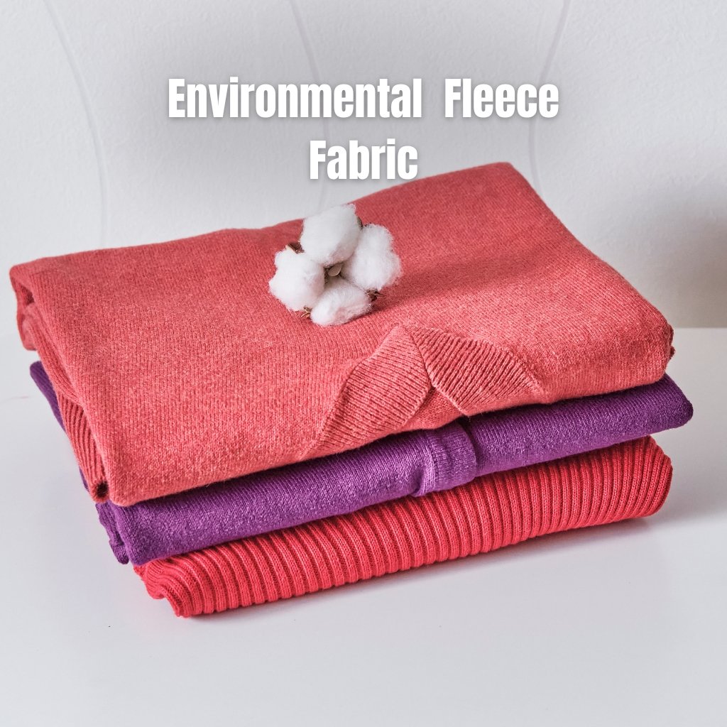 Stacked folded fleece fabrics in coral, purple, and red colors with a small cotton plant decoration on top.