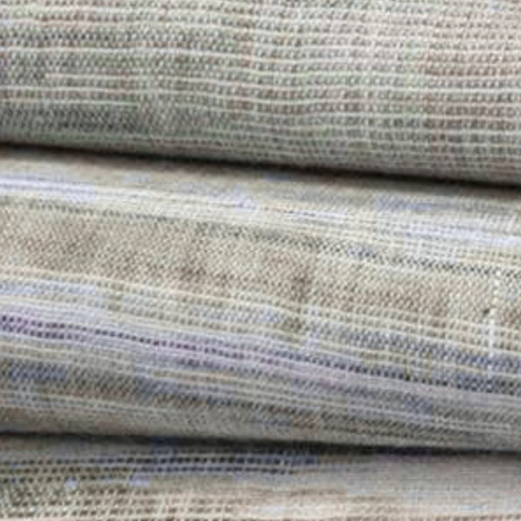 “Close-up of khadi cotton fabric with a coarse, irregular weave in natural off-white and beige tones, showing handwoven texture and subtle variations in color.