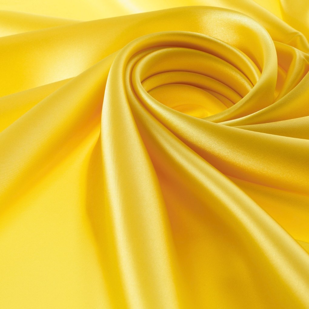 Close-up of shimmering metallic organza fabric in bright yellow-gold with smooth, reflective folds.