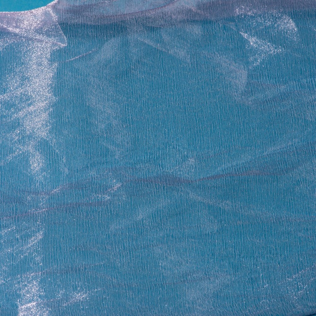 Close-up of shimmering mirror organza fabric with a metallic, reflective surface and soft, flowing folds.