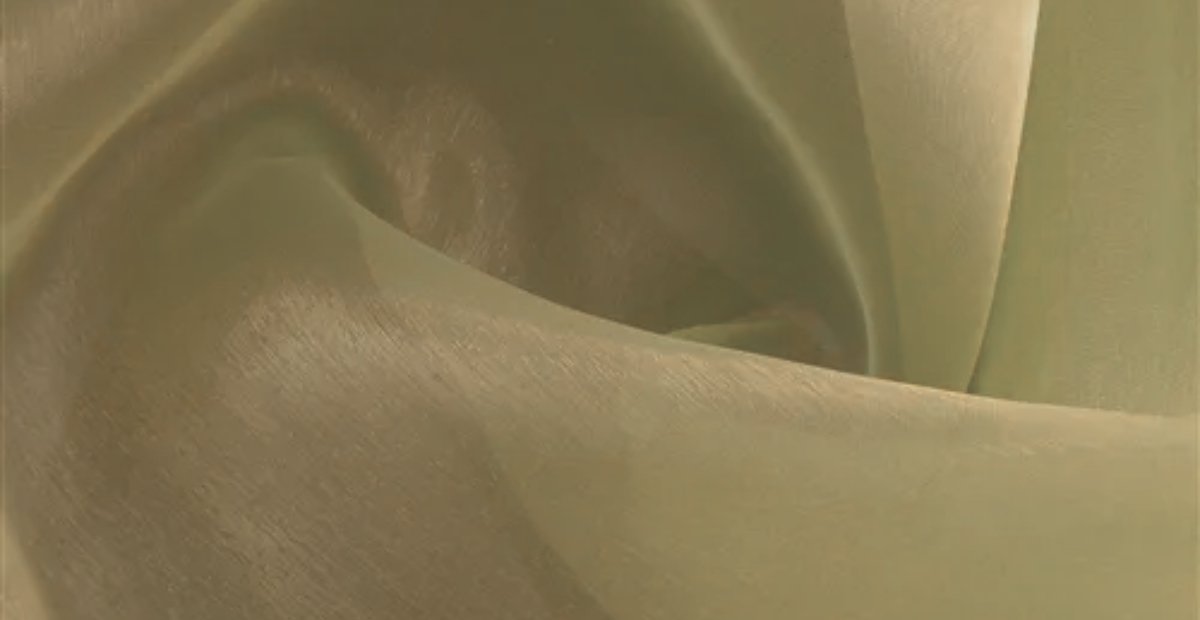 A close-up view of lightweight, sheer Polyester Organza fabric with a soft, pale gold/cream color. The fabric drapes in gentle folds, showing a subtle, silky sheen and a fine, crisp texture that catches light along the smooth surface and edges. polyester organza fabric