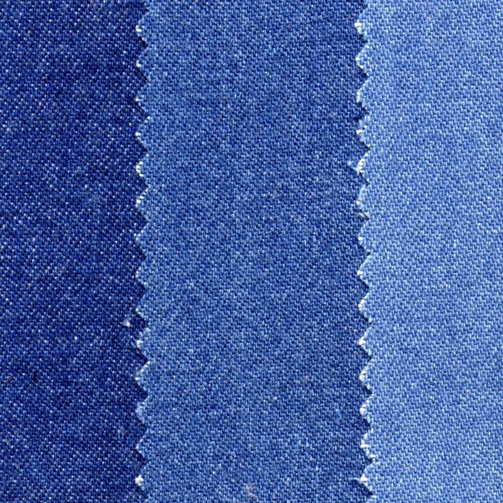 Close-up view of three denim fabric swatches in varying blue tones, with zigzag-cut edges showing distinct weave textures and shades from dark indigo on the left to lighter blue on the right. Making Process of Denim Jackets