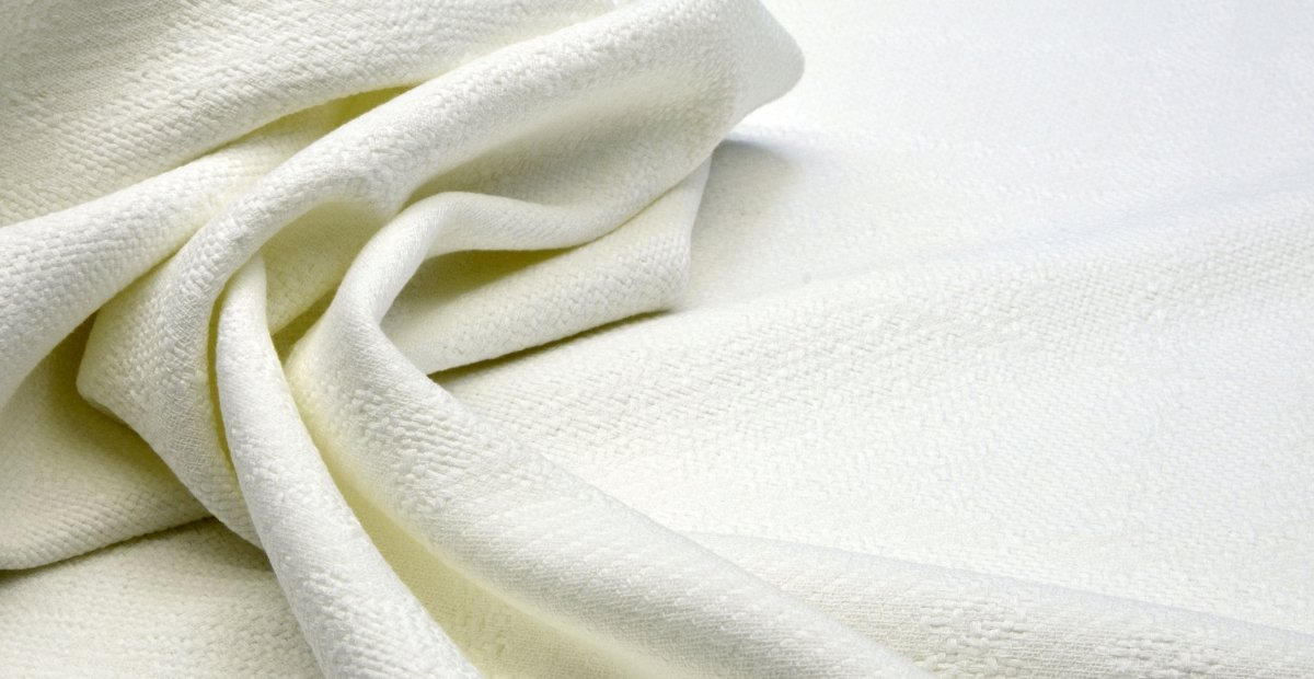 Why Supima Cotton Feels Softer, Stronger, and Smarter Close-up of soft, white fabric with folds and a textured surface.