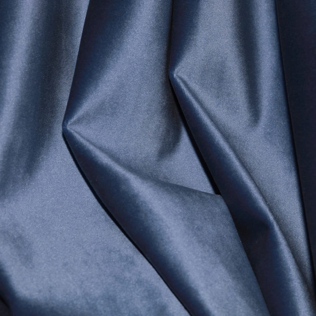 Close-up of luxurious velour cotton fabric in deep navy blue, showing a soft, plush nap and smooth, curved folds.

