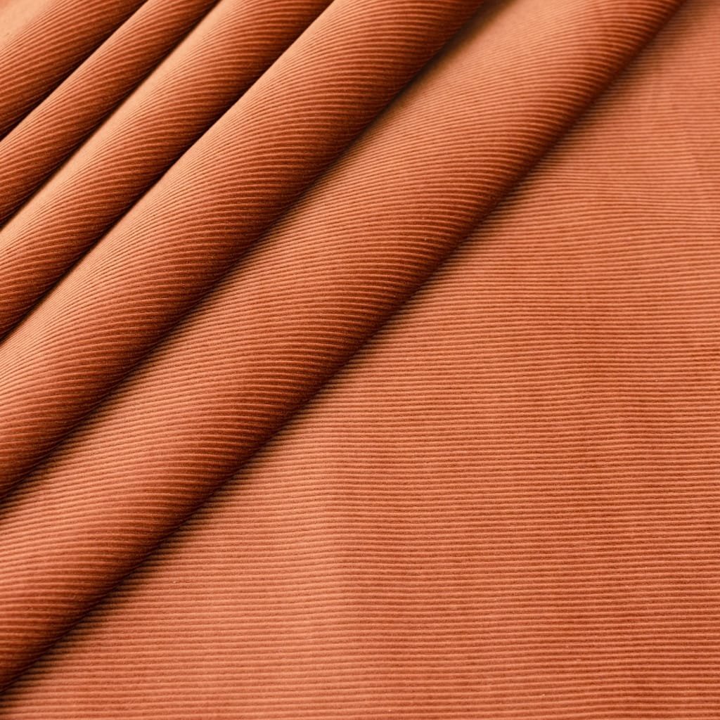 Close-up of velveteen cotton fabric in a warm terracotta color, showing a soft, plush nap and subtle diagonal rib texture.

