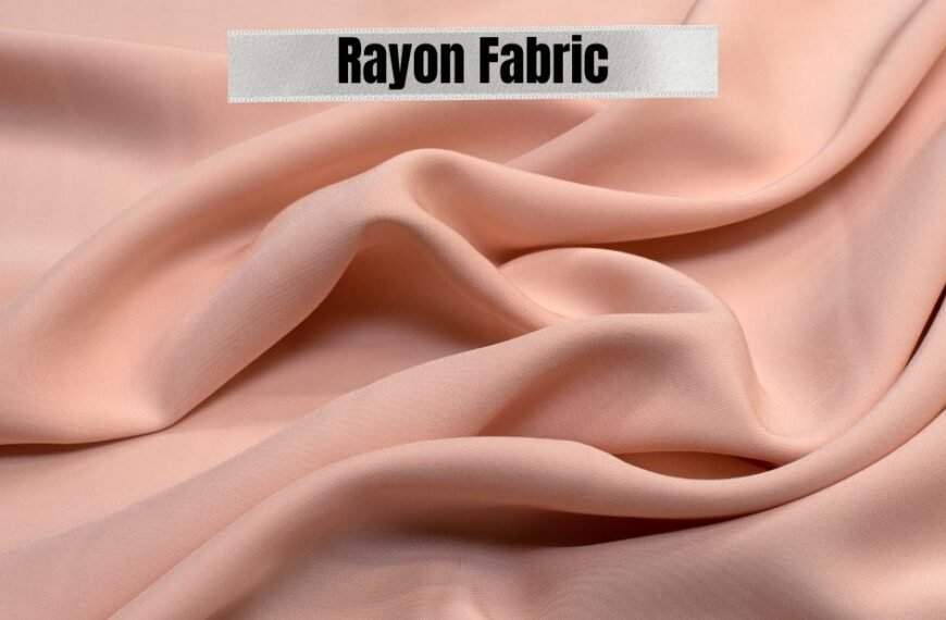 Close-up of soft, light peach rayon fabric with gentle folds, showcasing the texture.